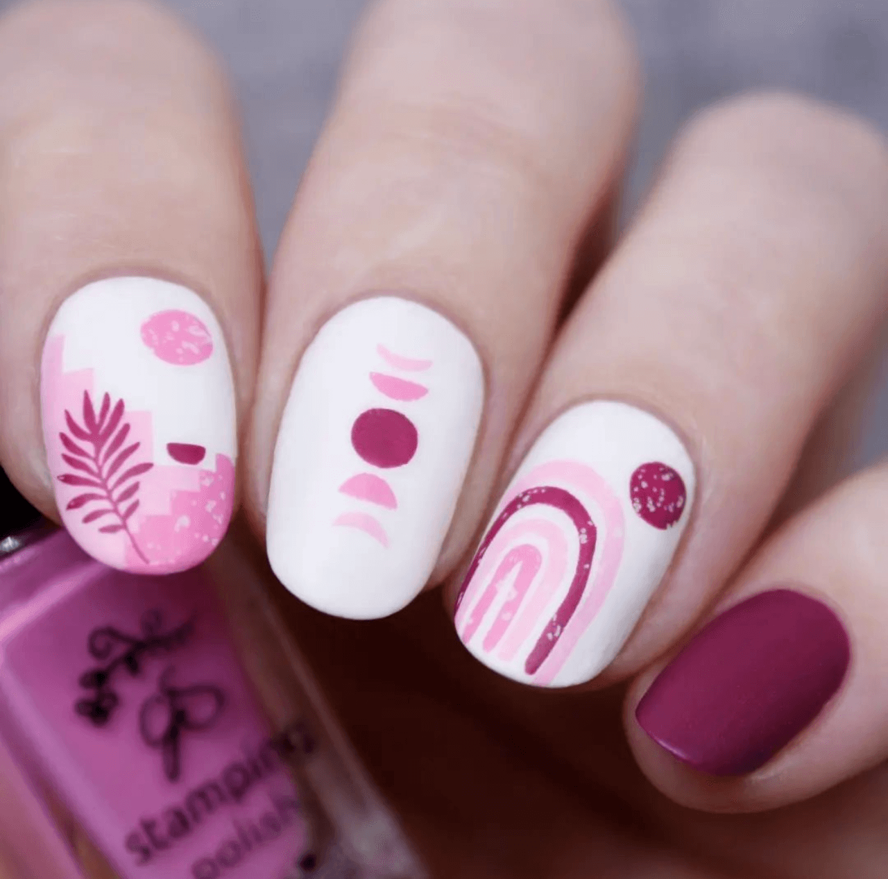 manicured-hand-with-layered-nail-art-designs-of-abstract-shapes-arches-and-palm-leaf