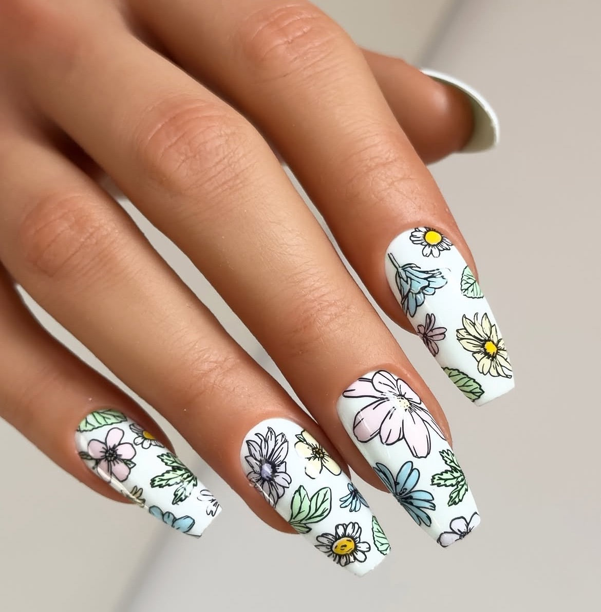 stunning-manicured-hand-with-full-coverage-nail-art-designs-of-a-variety-of-flowers-and-leaves