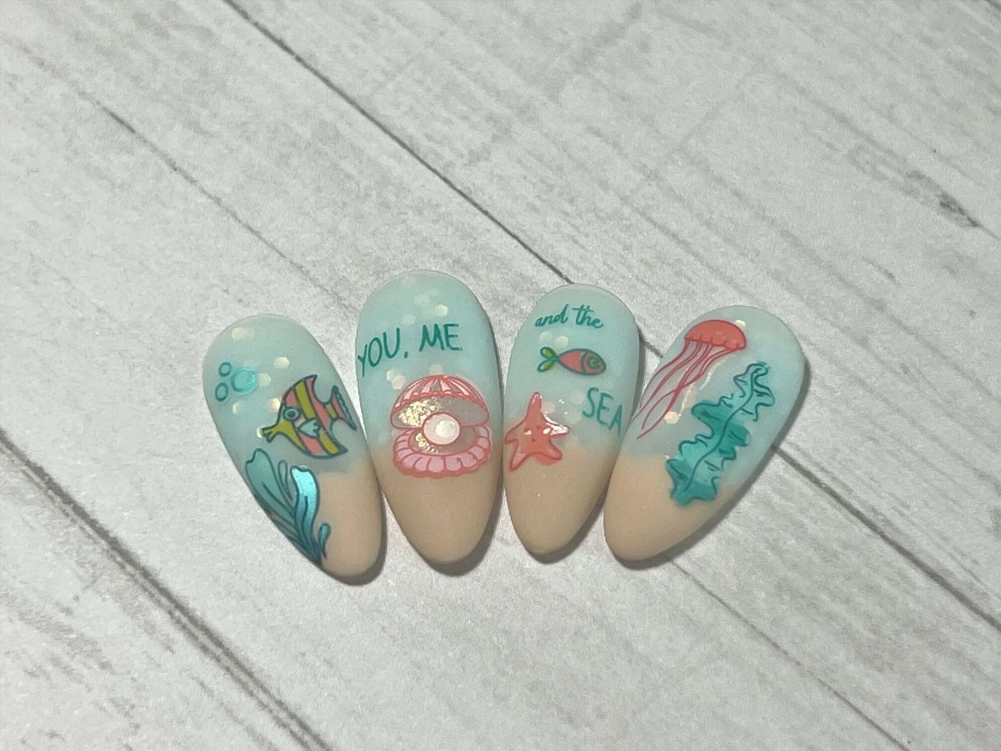 stunning-set-of-nail-tips-with-nail-art-designs-of-fish-starfish-jellyfish-and-the-words-you-me-and-the-sea