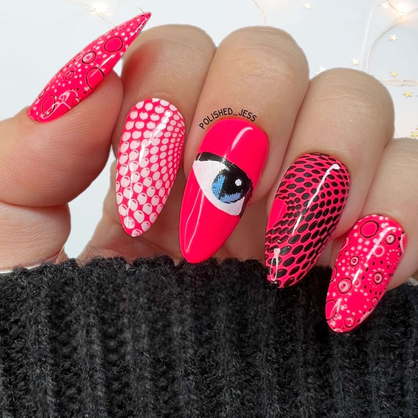 bright-hot-pink-manicure-with-abstract-nail-art-designs-of-an-eye-and-geometric-swirls