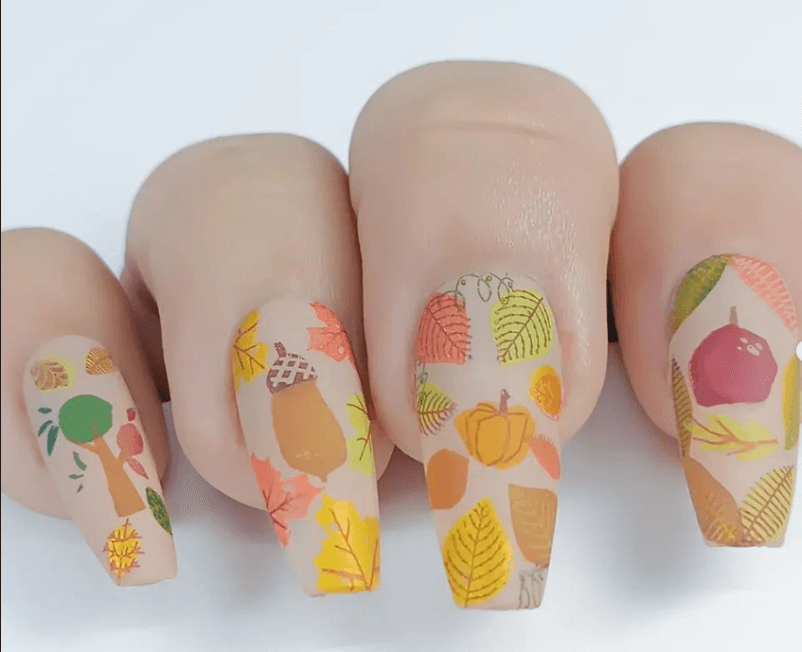 beautiful-matte-manicure-showing-fall-nail-art-designs-of-leaves-pumpkins-and-acorns