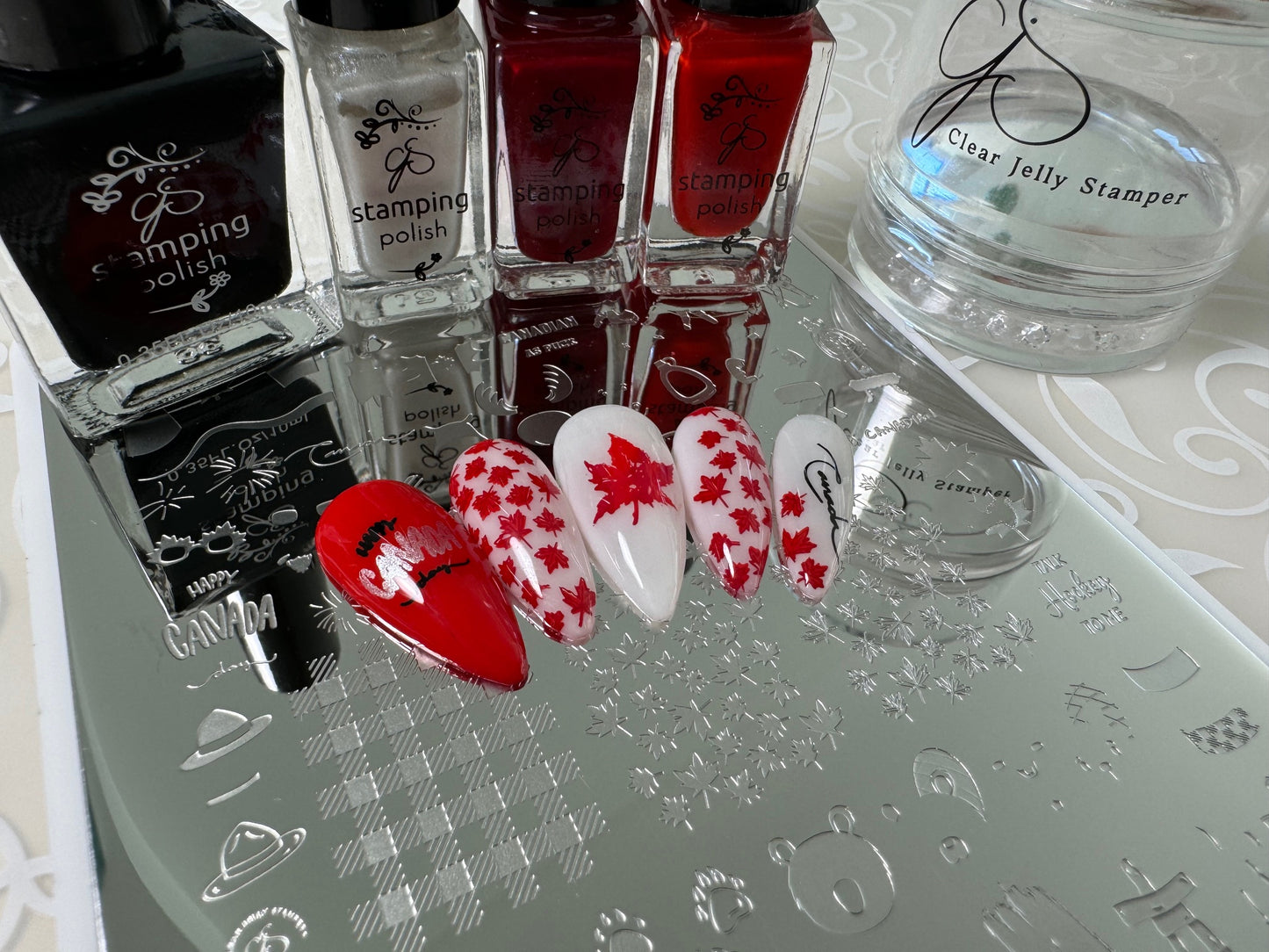 manicured-nail-tips-showing-nail-art-designs-of-canadian-maple-leafs-in-red-and-white-colors