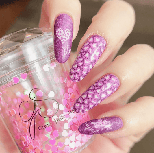 manicure-hand-with-heart-nail-art-designs-holding-an-amour-clear-jelly-stamper