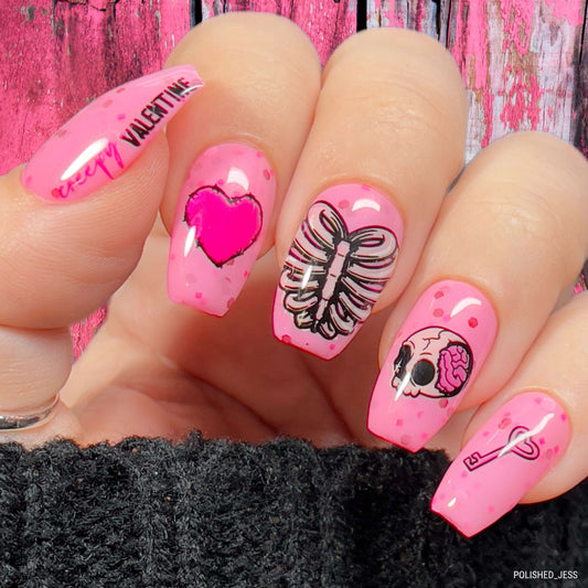 manicured-hand-with-bright-nail-art-designs-of-a-skull-rib-cage-barbwire-heart-and-words-creepy-valentines