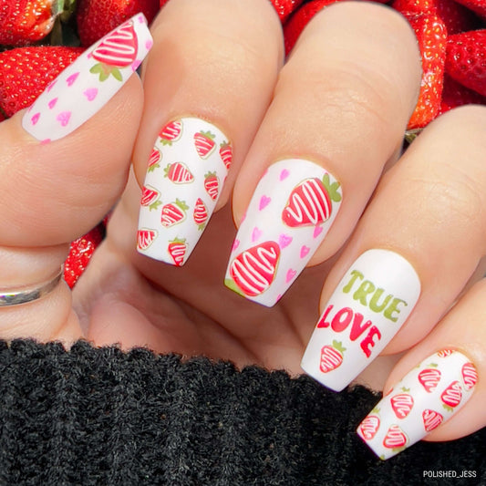 bright-manicured-hand-with-nail-art-designs-of-chocolate-covered-strawberries-and-words-true-love