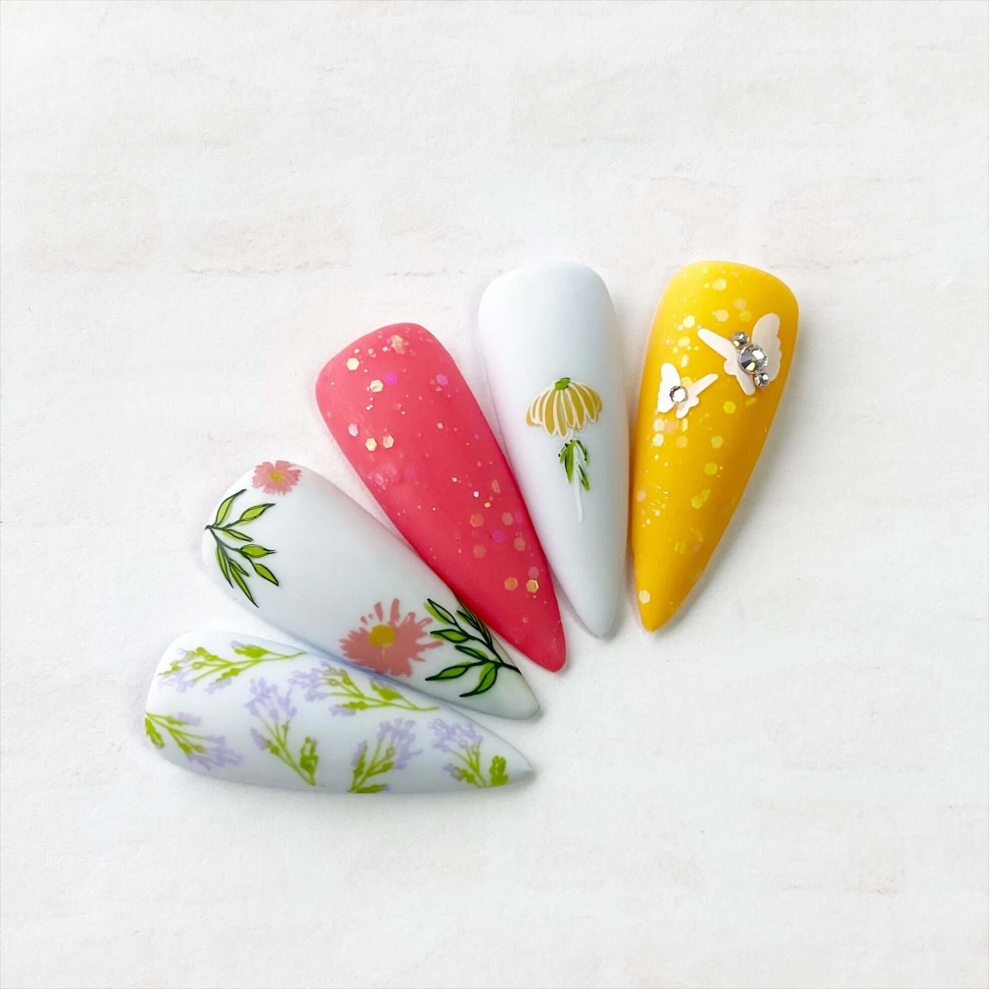 Set-of-nail-tips-with-beautiful-stamping-nail-art-designs-of-grasses-flowers-and-butterflies-with-nail-gems
