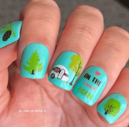 bright-manicure-with-nail-art-designs-of-trees-and-a-camping-trailer-with-words-on-the-road-again