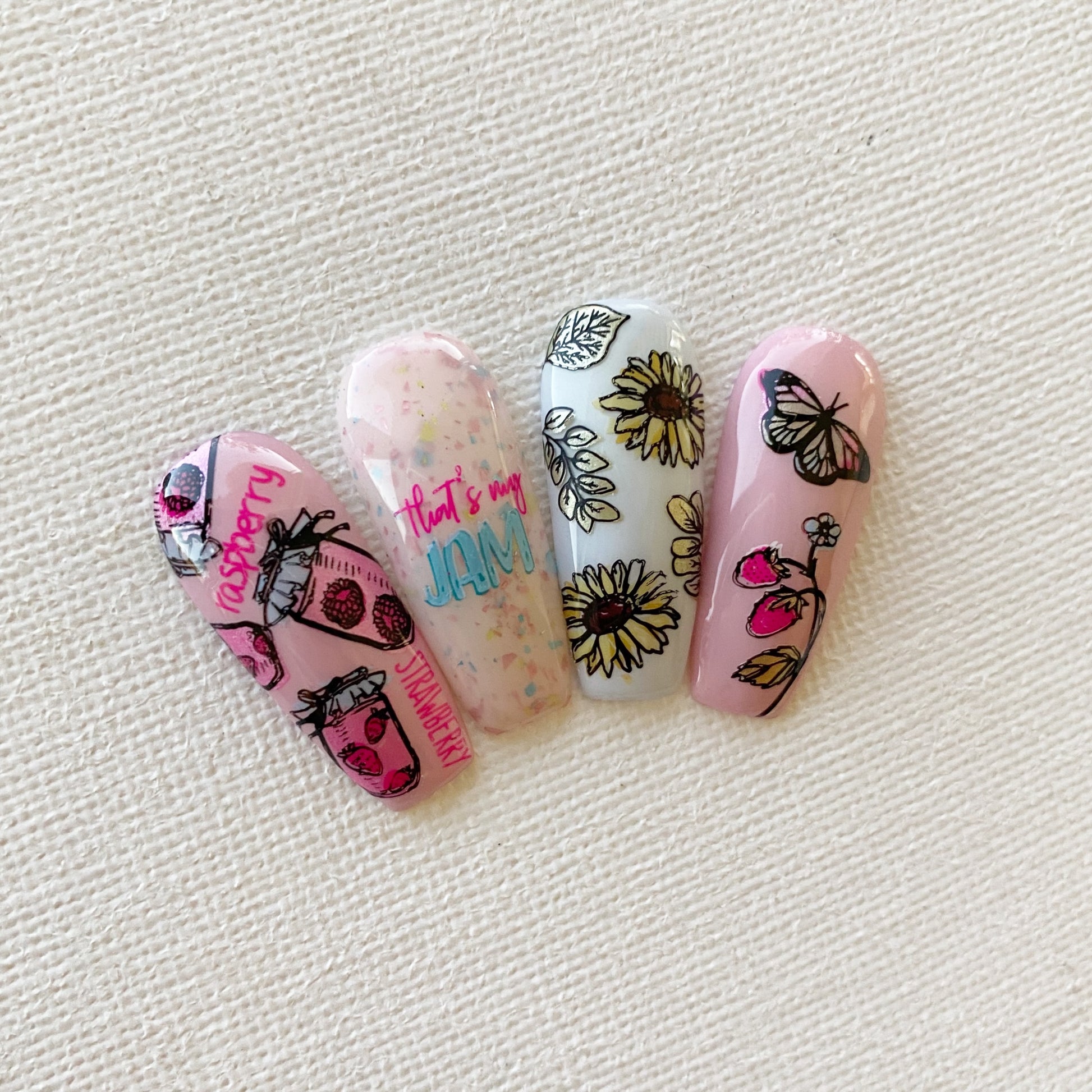 Set-of-nail-tips-with-nail-art-designs-of-raspberry-jam-jars-strwberry-plants-and-sunflowers-with-the-words-that's-my-jam