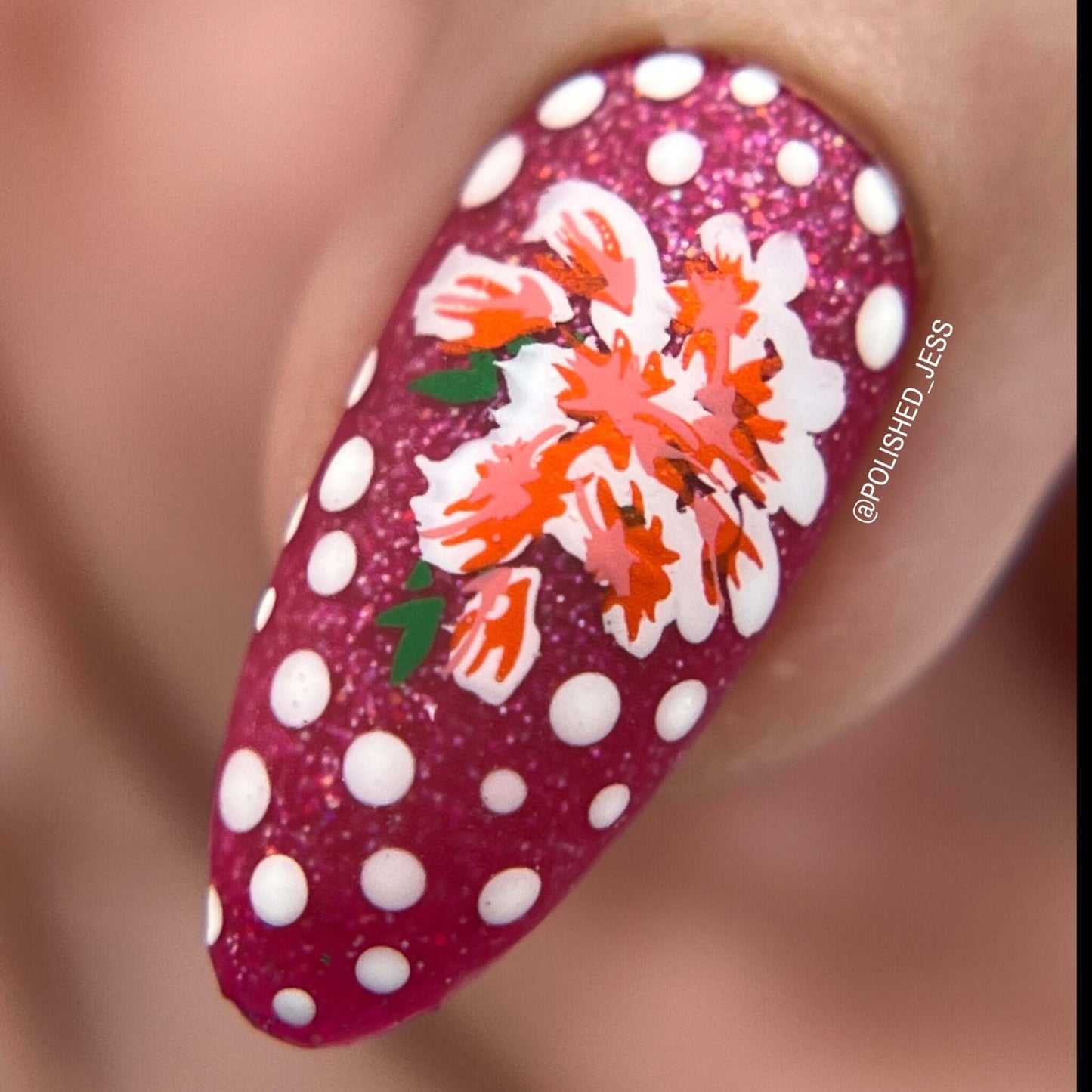 single-manicured-nail-showing-a-nail-art-stamping-design-of-flowers-with-dots-as-a-background