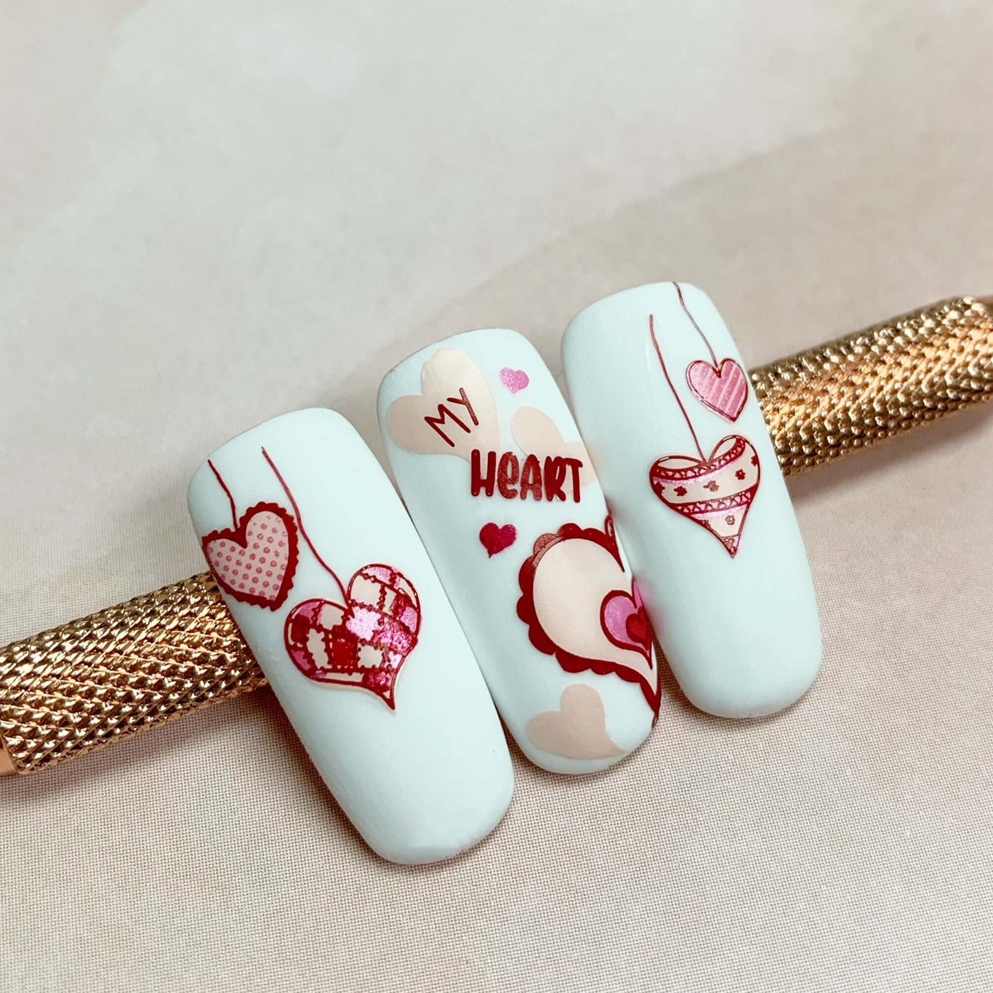 set-of-three-nail-tips-with-valentines-nail-art-designs-of-patchwork-hearts-and-words-my-heart