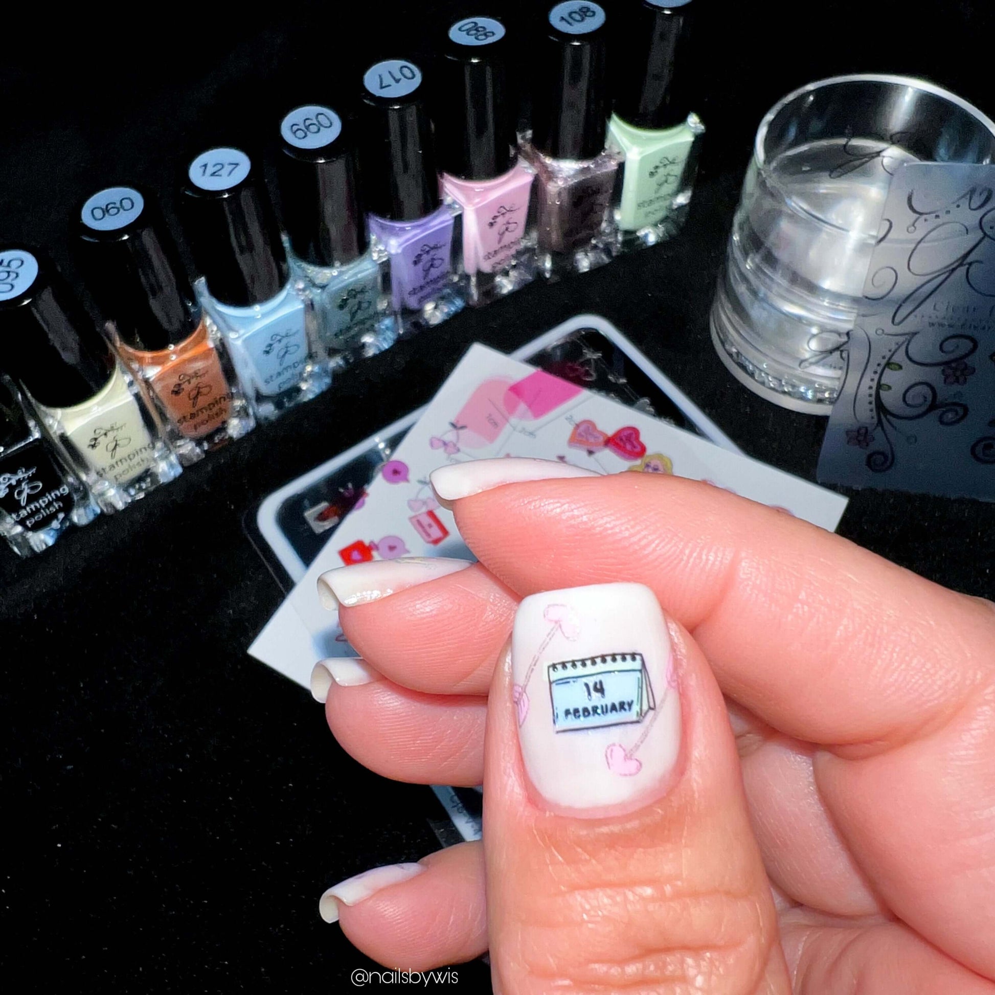 nail-art-tools-with-a-manicured-hand-showing-a-design-of-a-calander-and-words-14-february