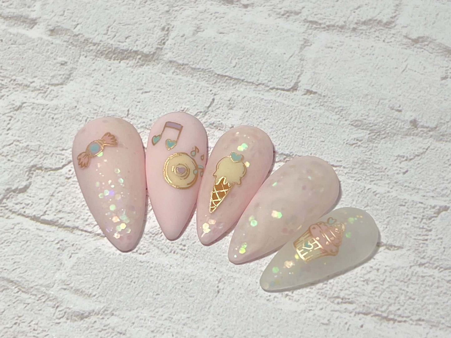 set-of-five-nail-tips-with-layered-nail-art-designs-of-a-cupcake-ice-cream-cone-and-music-notes