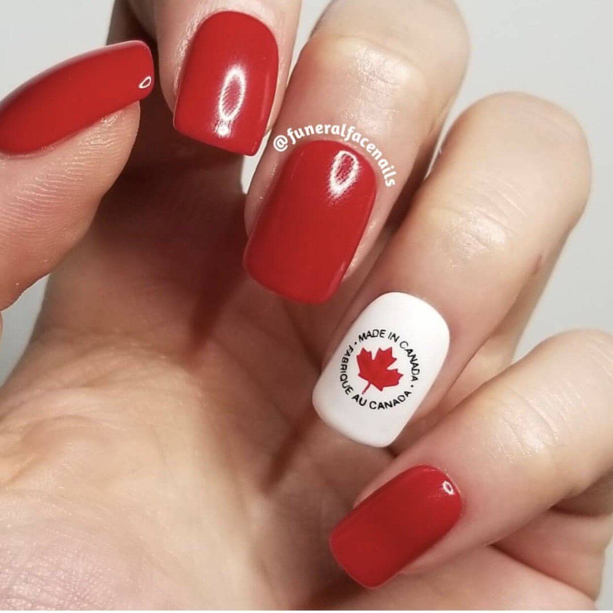 Red-and-white-manicure-showing-a-nail-art-design-of-a-maple-leaf-with-text-made-in-canada-
