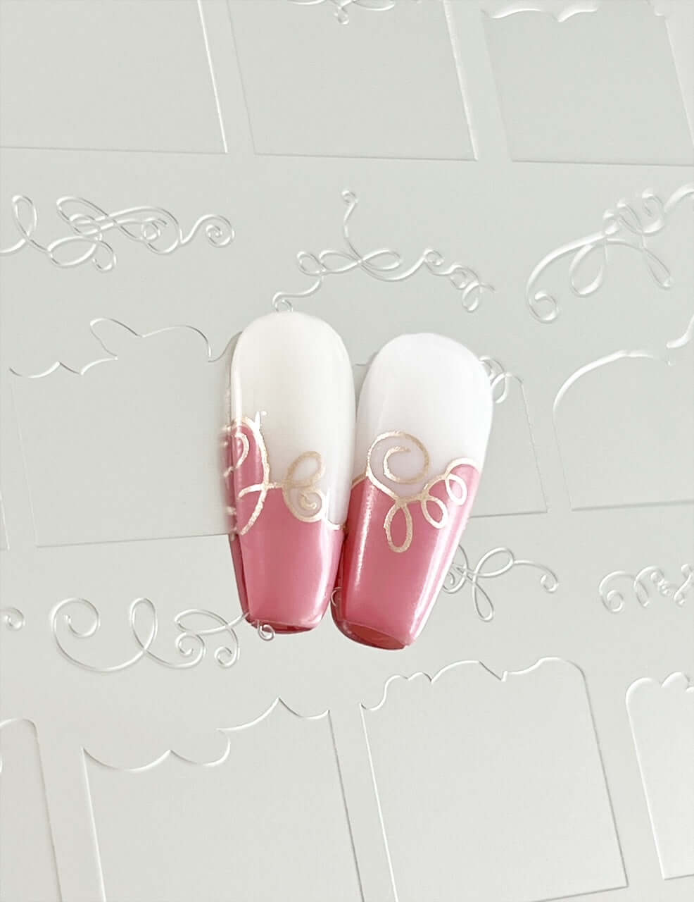 two-nail-tips-showing-french-tip-designs-with-nail-art-swirls-on-in-pink-and-white