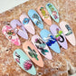 set-of-nail-tips-with-stunning-nail-art-designs-of-mermaid-tails-waves-and-seashells