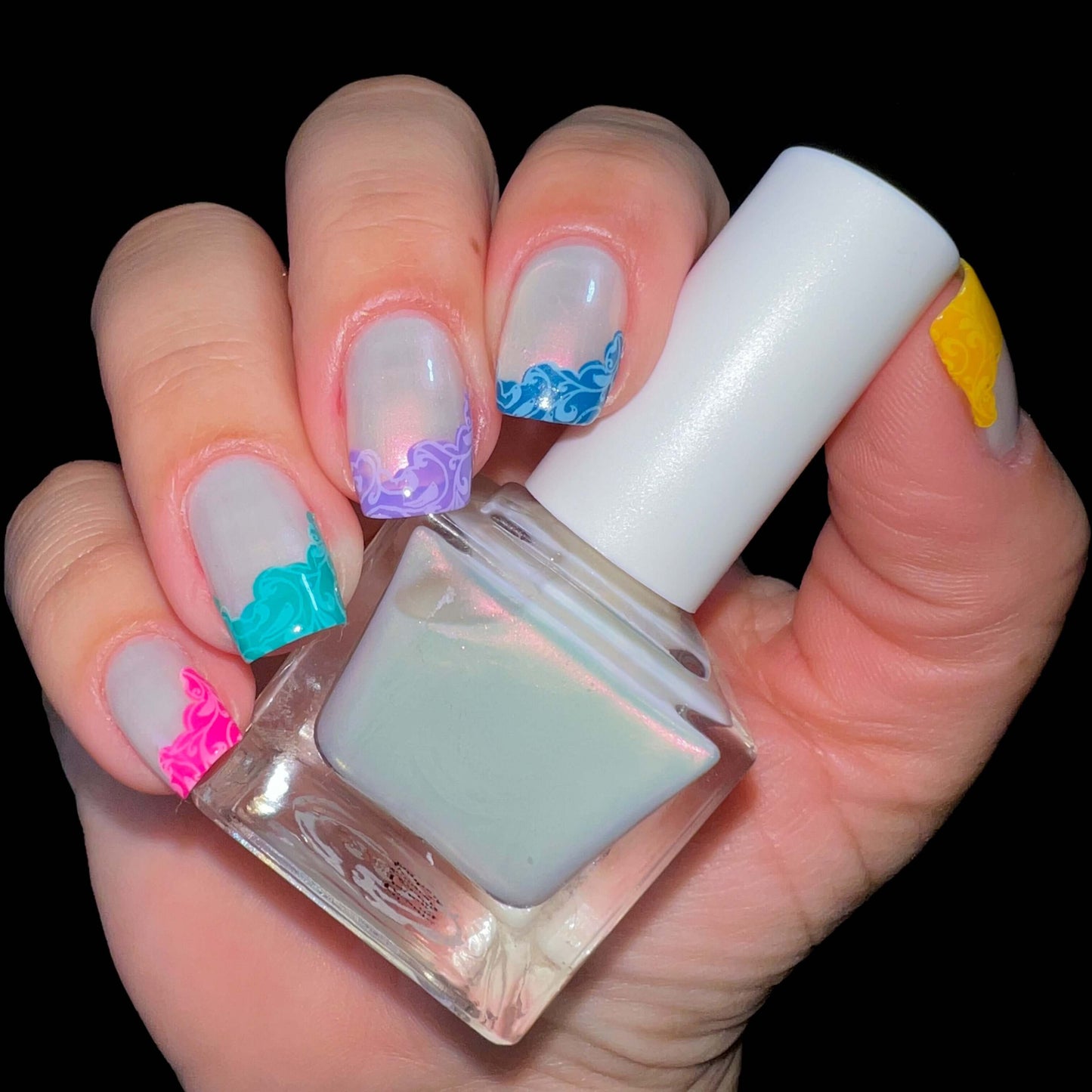 manucired-hand-showing-nail-art-french-tip-designs-with-swirls