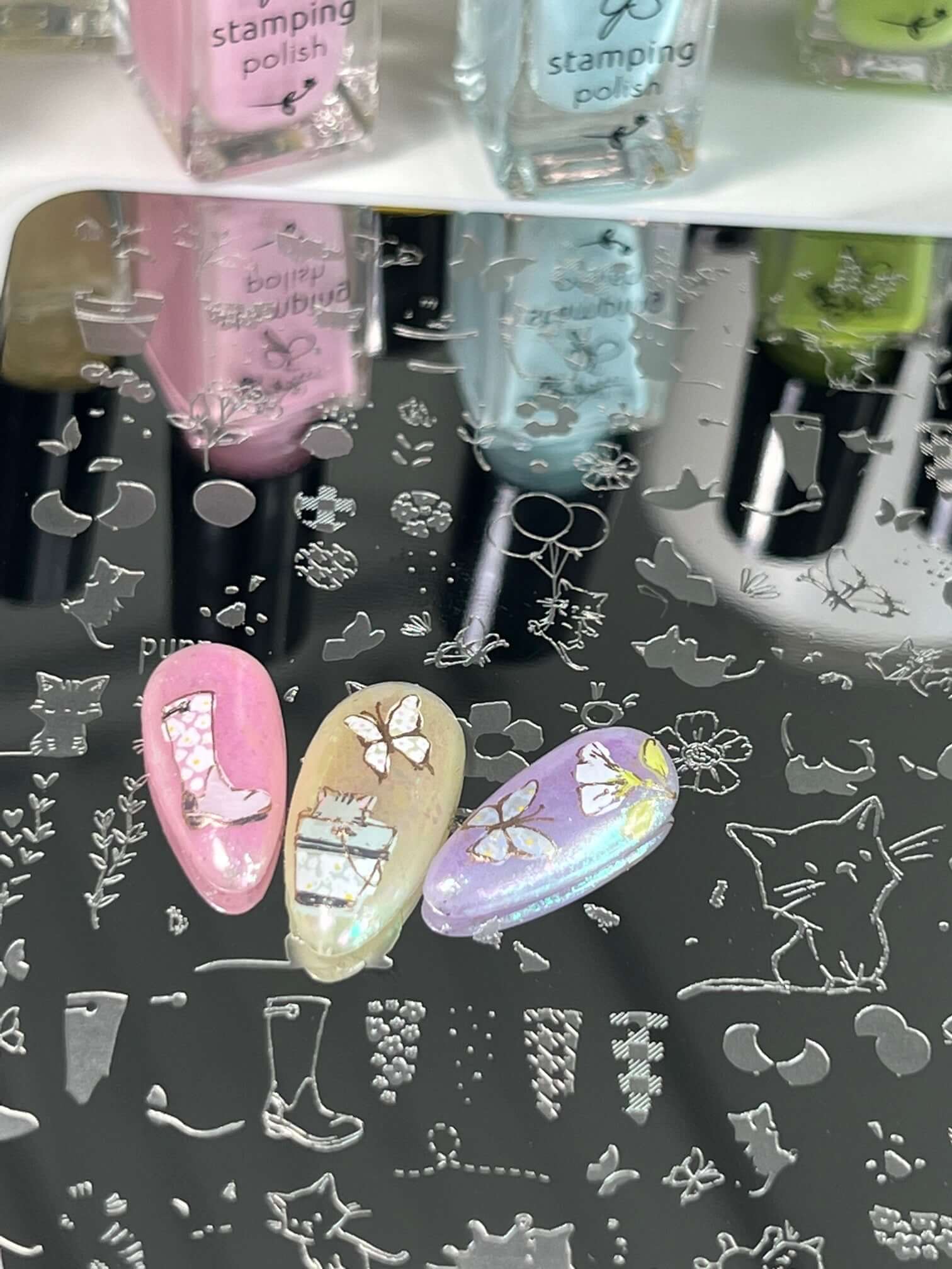 three-nail-tips-with-nail-art-designs-of-butterflies-and-a-kitten-in-a-bucket