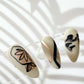 Three-white-nail-tips-showing-modern-nail-art-designs-of-abstract-shapes-gold-and-black
