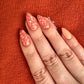 Burnt-orange-manicure-with-full-coverage-nail-art-designs-in-a-floral-pattern