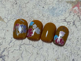 a-set-of-nail-tips-showing-a-nail-art-design-of-flowers-and-a-dragonfly