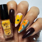 manicured-hand-holding-bottle-of-nail-stamping-polish-showing-abstract-flower-nail-art-designs
