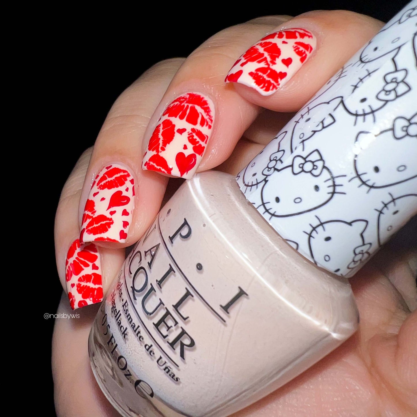 stunning-manicured-hand-with-nail-art-designs-of-lip-stick-print-and-hearts-holding-a-bottle-of-nail-polish