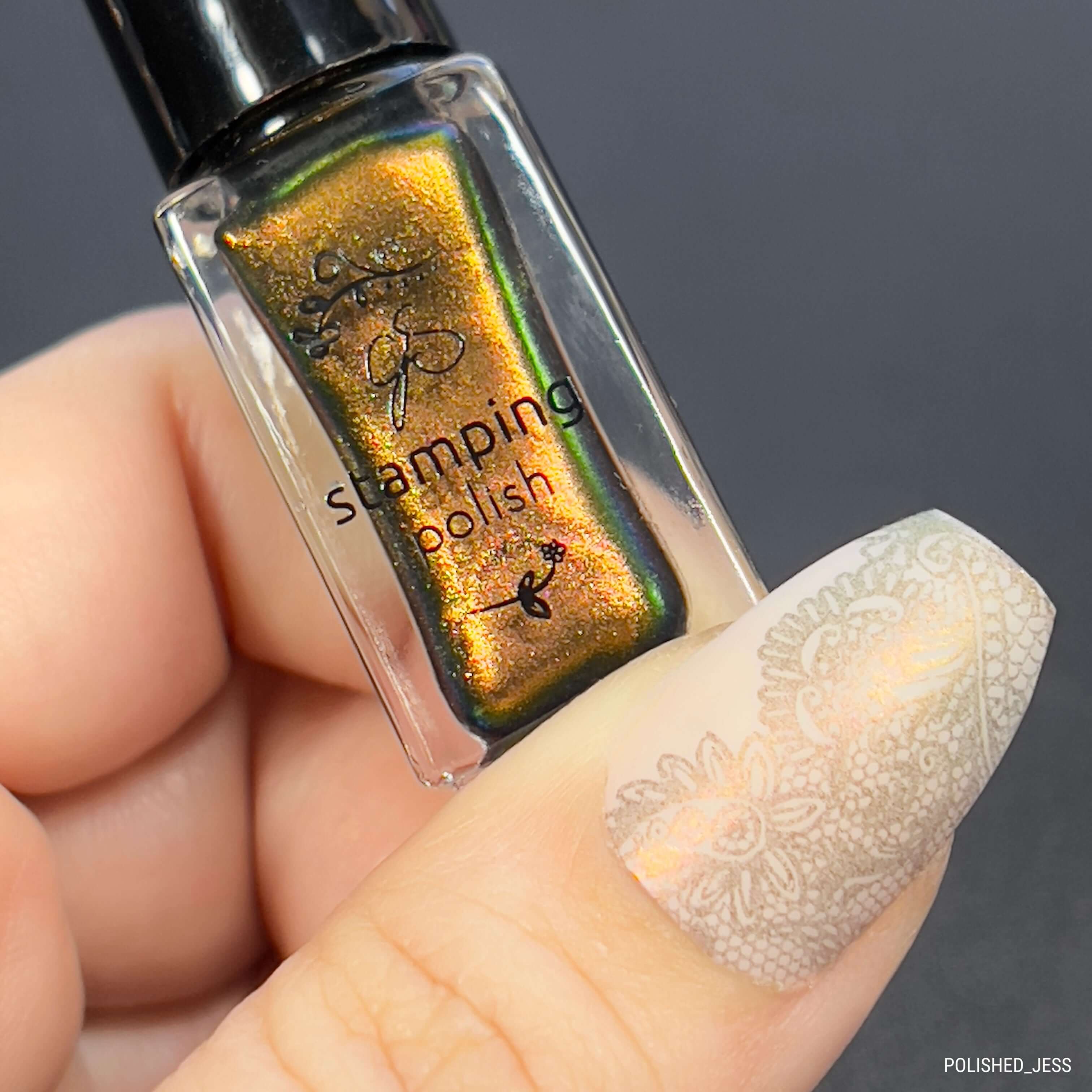 manicured-hand-holding-a-stamping-polish-bottle-with-stunning-lace-nail-art-designs-on-thumb