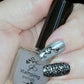 manicure-hand-holding-a-clear-jelly-polish-with-nail-art-designs-of-swirly-vines