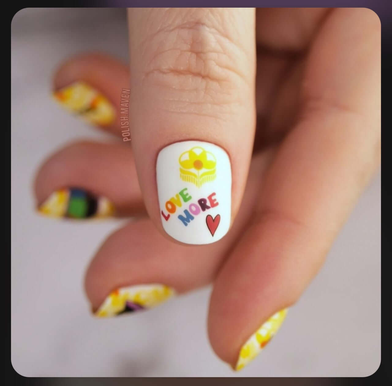 single-manicured-thumb-nail-with-cute-nail-art-design-of-heart-and-retro-flower-with-words-love-more