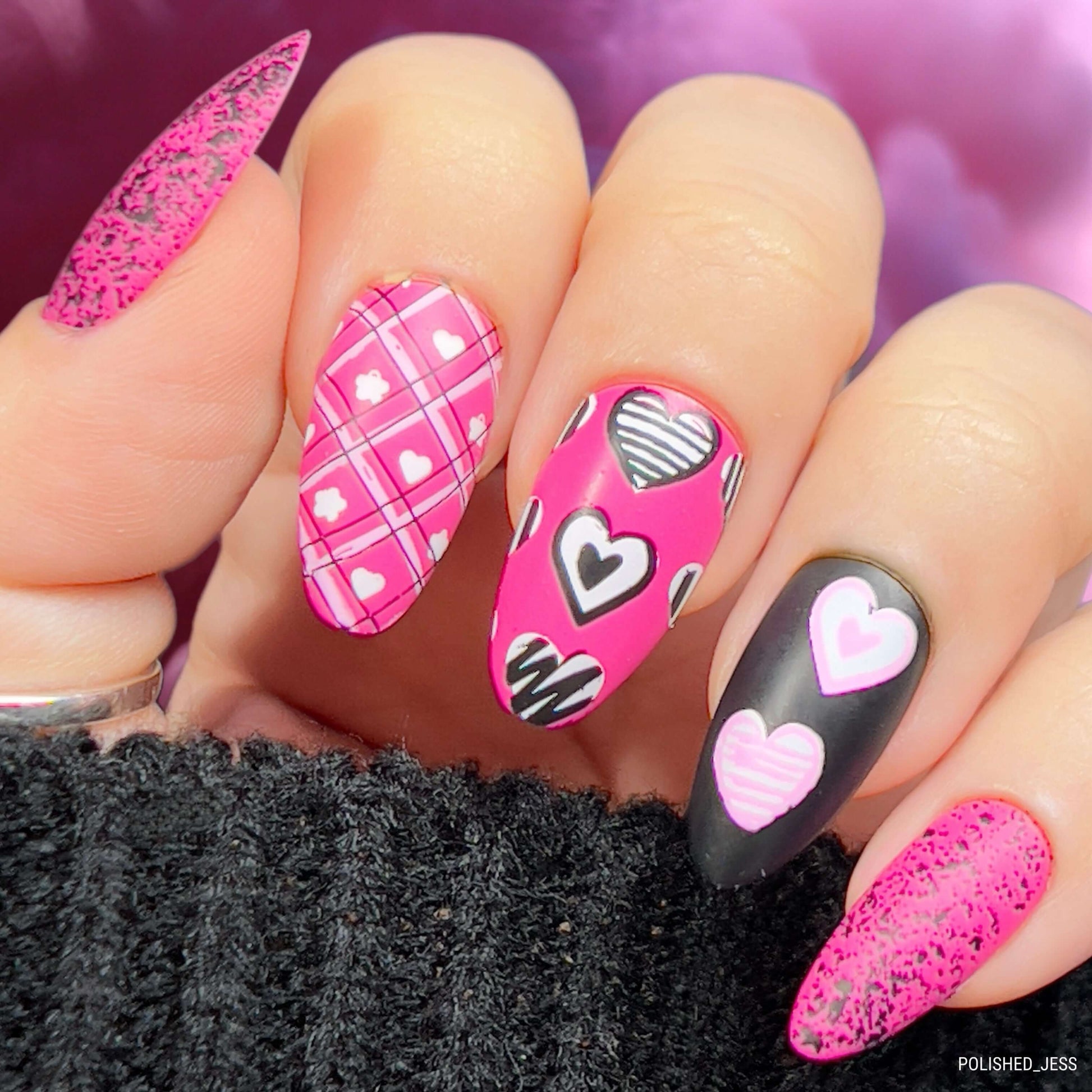 maniucred-hand-with-bright-nail-art-designs-of-hearts-with-patterns-on