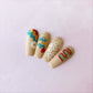 set-of-manicured-nail-tips-with-nail-art-designs-of-daisies-retro-waves-and-the-words-self-love-club