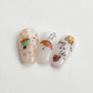 three-nail-tips-showing-colorful-nail-art-designs-of-autumn-leaves-pumpkins-and-words-bring-on-the-color