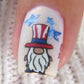 single-manicured-nail-showing-a-nail-art-design-of-a-gnome-wearing-a-usa-hat