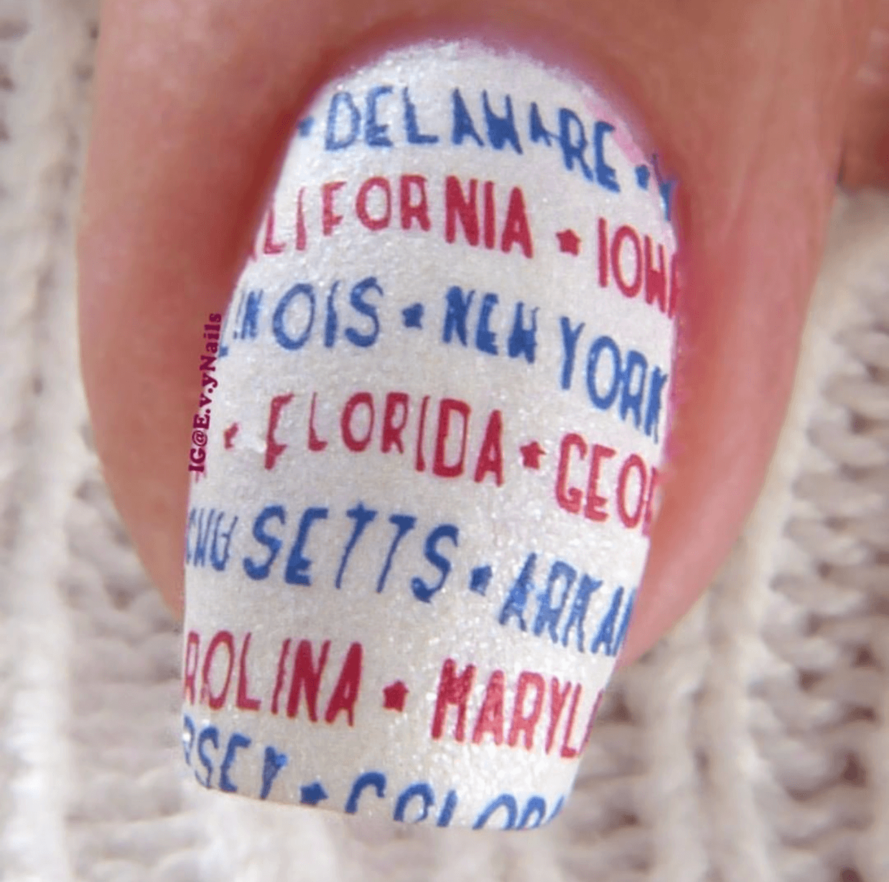 Single-manicured-nail-showing-text-of-the-us-states-in-nail-art