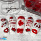manicured-nail-tips-showing-nail-art-designs-in-red-and-white-of-maple-leaves-canada-flag-and-nail-art-words