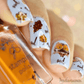 manicure-showing-nail-art-designs-of-an-owl-with-leaves-holding -a-bottle-of-stamping-polish