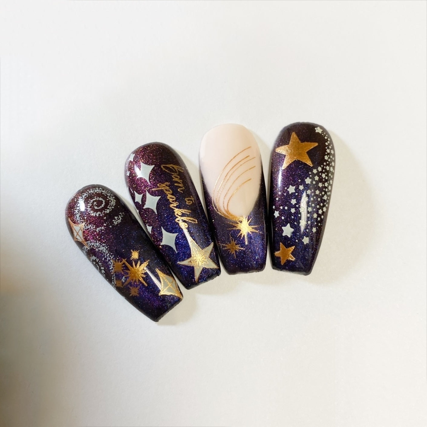 set-of-nail-tips-with-stamping-nail-art-designs-of-different-sized-stars-and-the-words-born-to-sparkle