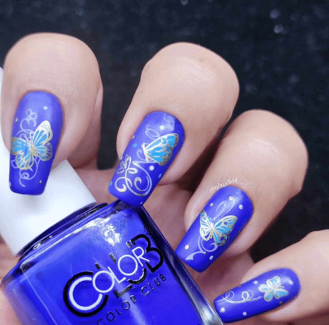 bright-blue-manicure-with-shimmery-nail-art-designs-of-butterflies-and-swirls