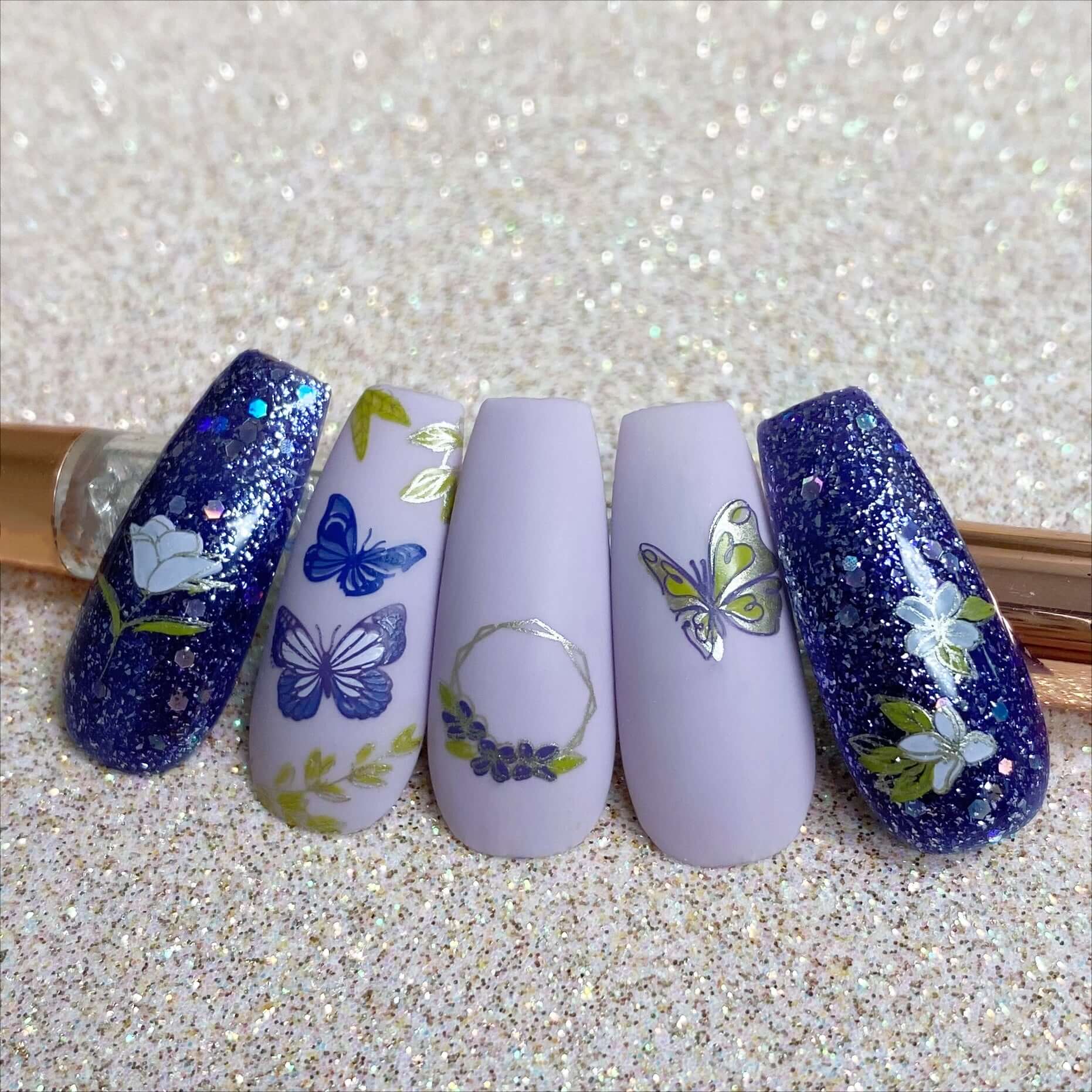 set-of-nail-tips-showing-stunning-layered-nail-art-designs-of-butterflies-flowers-and-a-floral-wreath