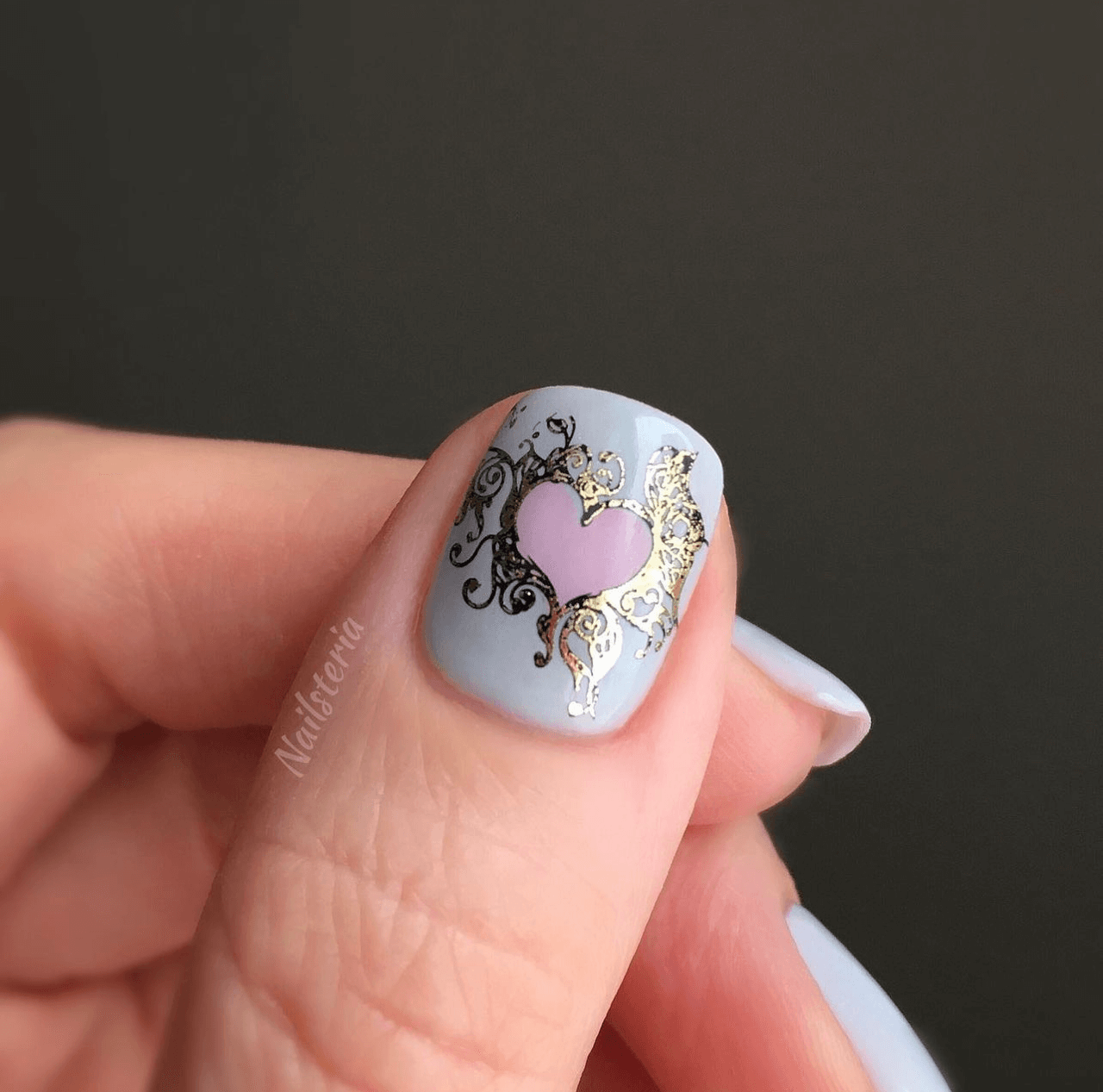 single-manicured-nail-with-a-swirling-heart-layered-nail-art-design