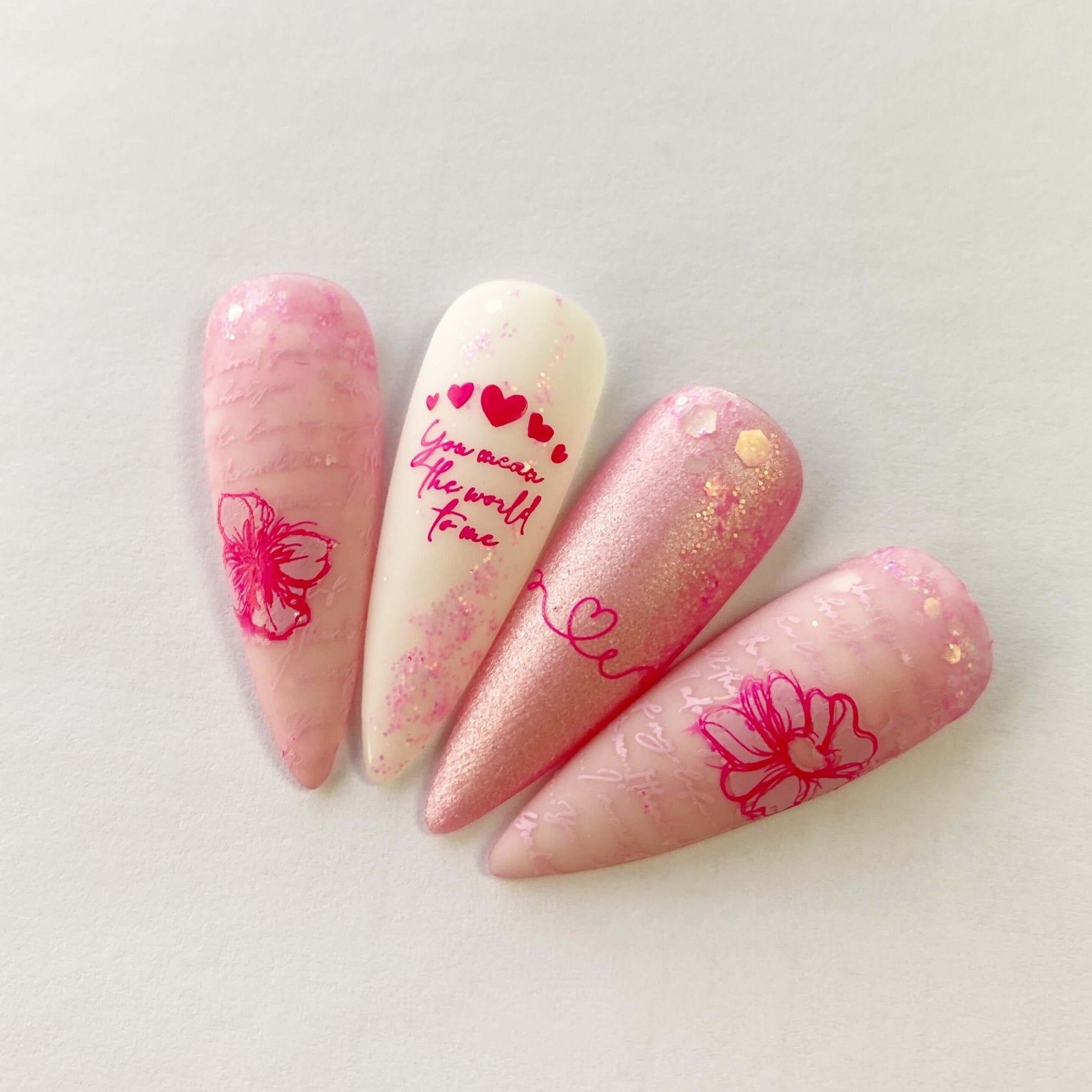 set-of-nail-tips-with-stunning-layered-nail-art-designs-of-flowers-hearts-and-script