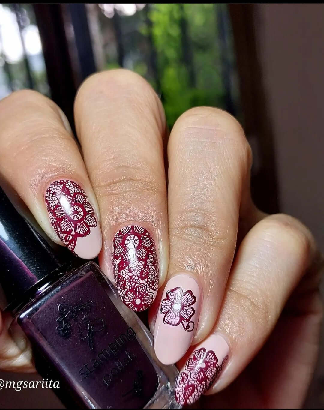 manicured-hand-holding-stamping-polish-with-lace-nail-art-designs