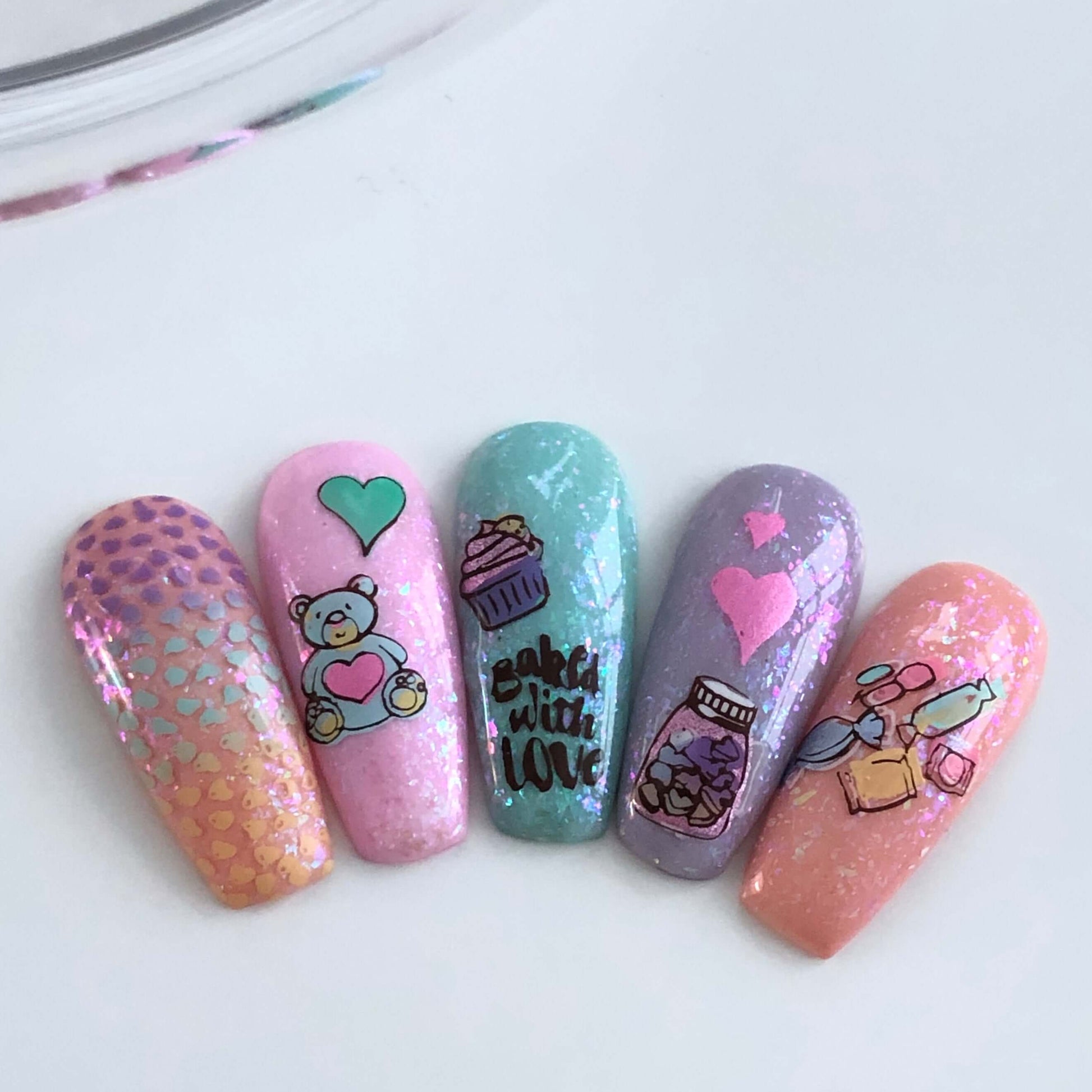 set-of-nail-tips-with-cute-valentines-nail-art-designs-of-treats-a-teddy-bear-cupcake-and-words-baked-with-love