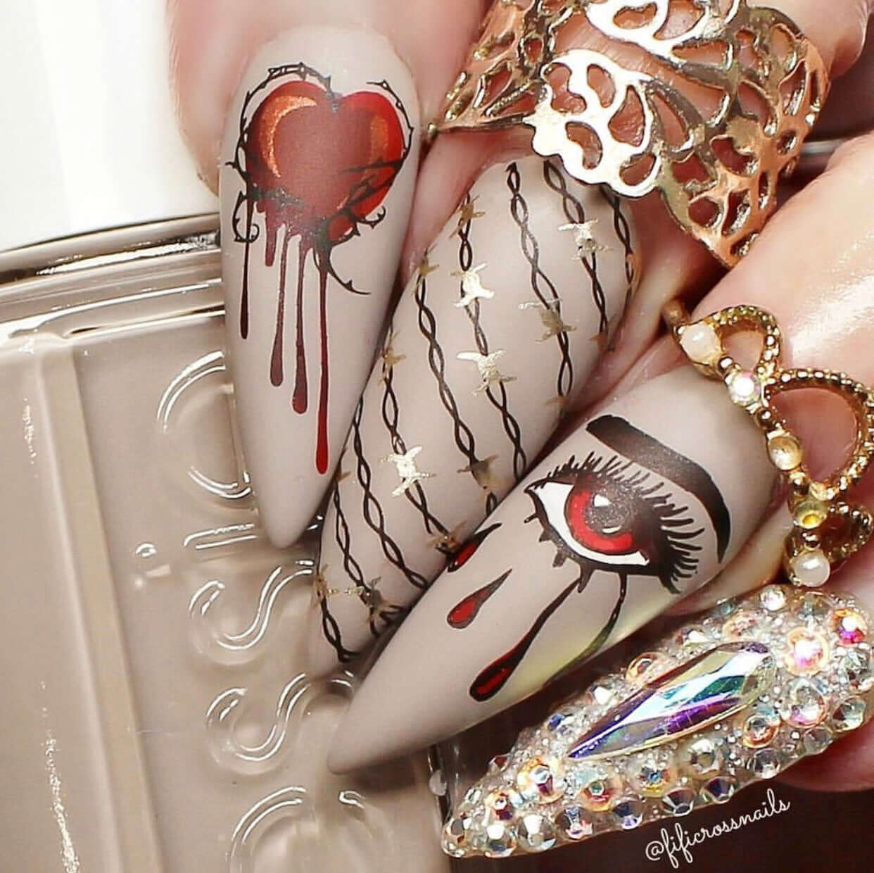Manicure-showing-nail-art-designs-of-a-heart-dripping-blood-an-eye-crying-blood-and-barbwire